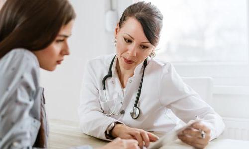Women's health nurse practitioner referencing test results with patient